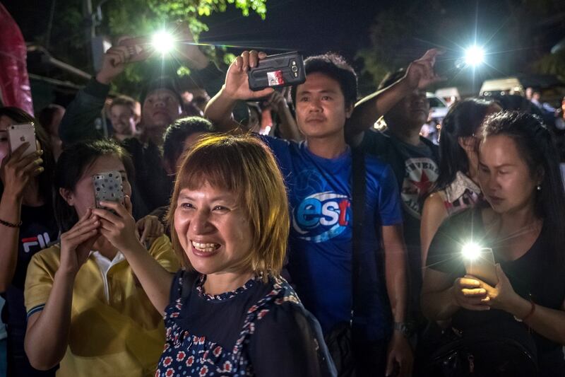 Onlookers watch and cheer as ambulances transport the last rescued schoolboys and their coach to hospital. Photograph: Linh Pham/Getty Images
