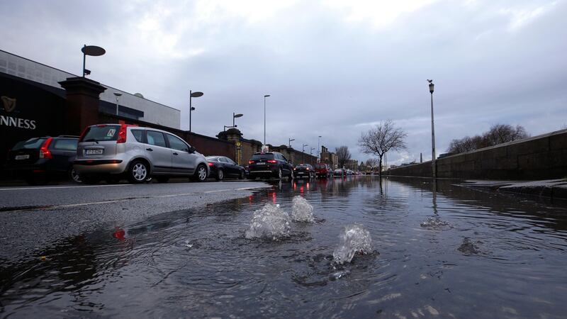 Water rises from the road as traffic makes its way along a flooded Victoria Quay in Dublin City centre on Saturday during Storm Dennis. Photograph: Damien Eagers/The Irish Times.