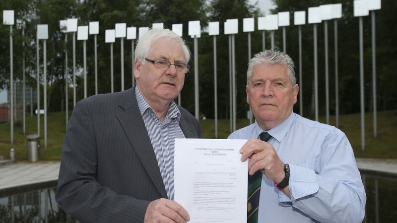 Michael Gallagher (left) who lost his son Aiden, and Stanley McComb (right), who lost his wife Ann in the Omagh bombing hold a writ in the Omagh Memorial Garden. Photograph: Niall Carson/PA