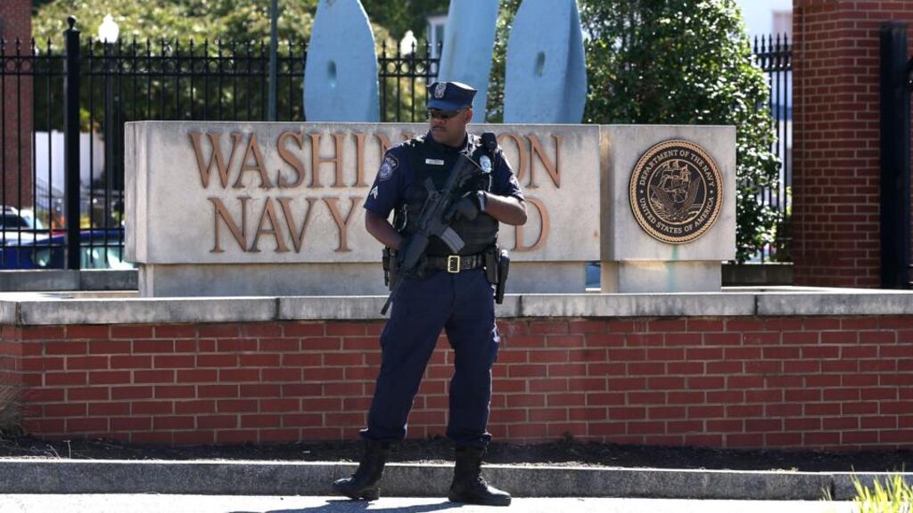 An armed guard stands outside the Washington DC naval facility following Monday’s shootings. Aaron Alexis’s job loss is being considered as a triggering factor for his killings. Photograph: Mark Wilson/Getty Images