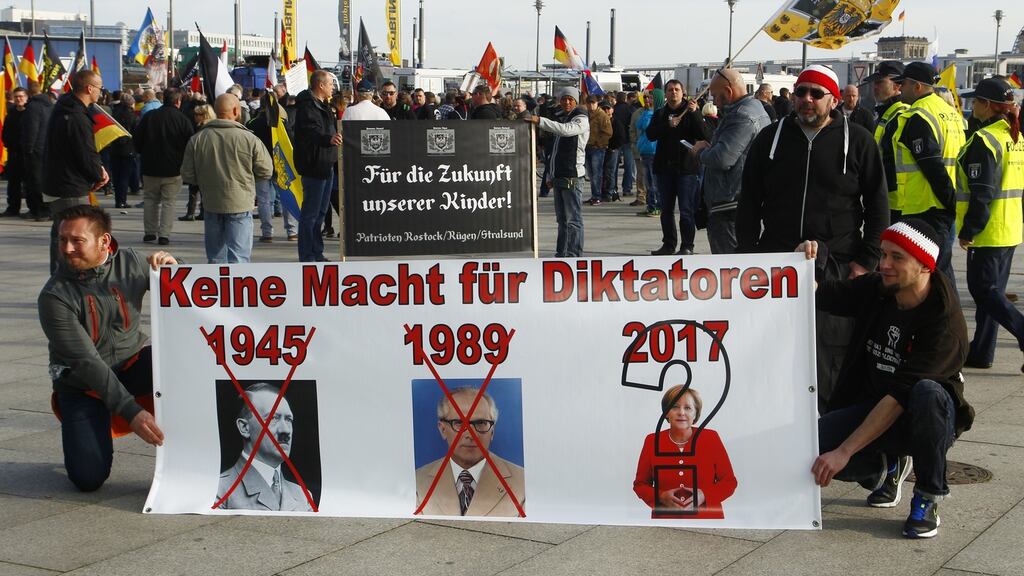 Protesters hold a placard with right-wing slogans against the government: Germany faces federal elections in September and pressure on the refugee situation is building. Photograph: Michele Tantussi/Getty Images