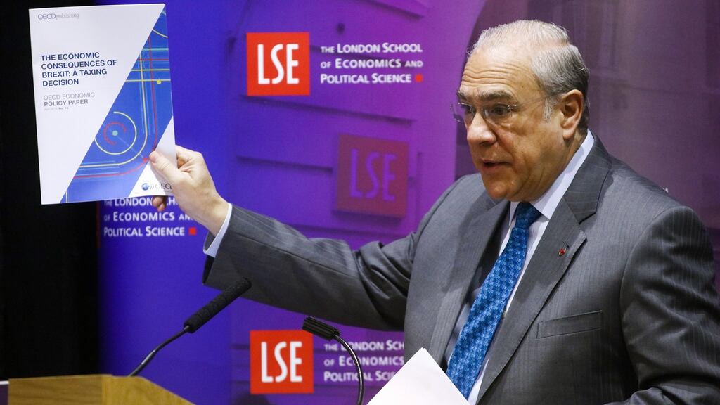 Jose Angel Gurria, secretary-general of the OECD, holds up his organisation’s policy paper on the effects of Brexit during a speech at the London School of Economics on Wednesday. It became the latest international body to warn the UK that leaving the European Union would cause lasting damage to the economy. Photograph: Chris Ratcliffe/Bloomberg
