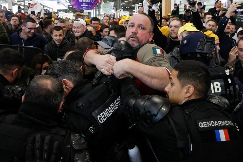 French farmers face French authorities during the protest at the Porte Versailles exhibition centre. Photograph: Kiran Ridley/AFP