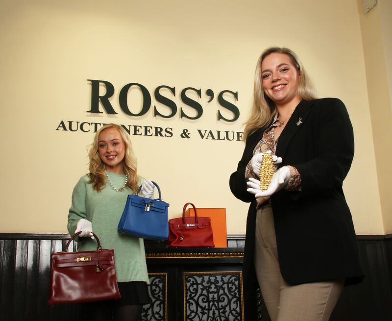 Philippa Harty and Lauren Frayne from Ross's Auctioneers  with the Elizabeth Taylor bracelet and three  Hermes bags