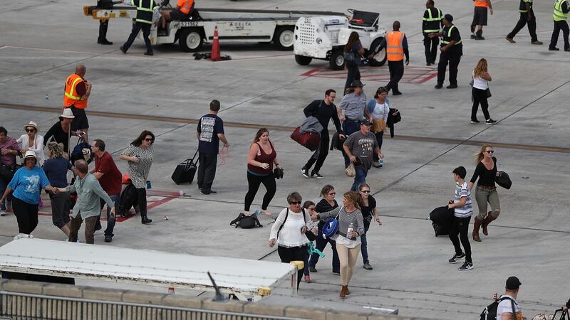People seek cover on the tarmac of Fort Lauderdale-Hollywood International airport after a shooting took place near the baggage claim. Photograph: Joe Raedle/Getty Images