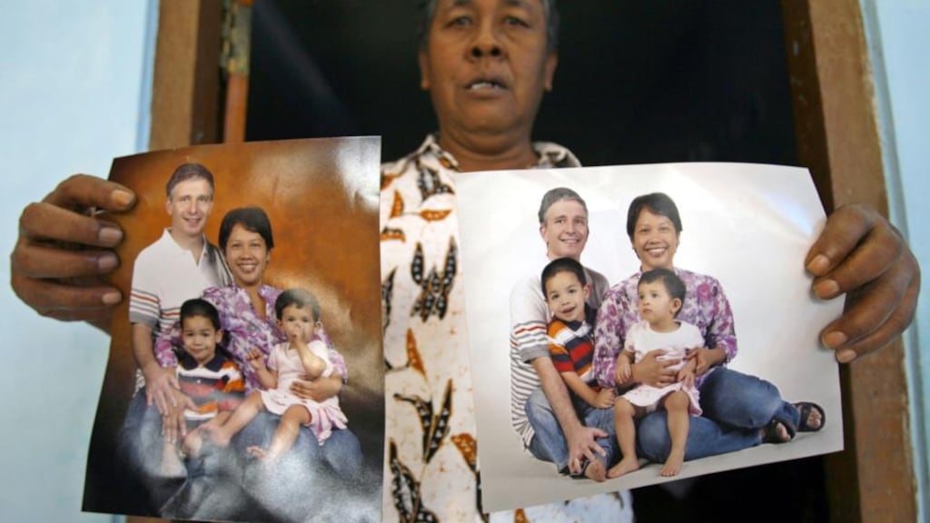 Widi Yuliono shows photographs of his relativesJohn Paulisen (Top-L), Yuli Hastini (Top-R), Arjuna Martin Paulisen (L) and Sri Paulisen (R) who are victims of the Malaysian Airline flight MH 17 plane disaster in eastern Ukraine, at his home in Solo, Central Java, Indonesia. Photograph: Mohammad Ali/EPA