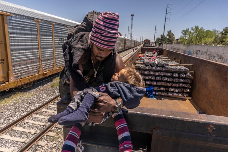 A Venezuelan migrant and his child ride disembark from a train in Ciudad Juárez, Mexico. Many people have rushed to the border as a pandemic-era health restriction that the US used to quickly expel migrants who crossed the border illegally expires. Photograph: Alejandro Cegarra/New York Times