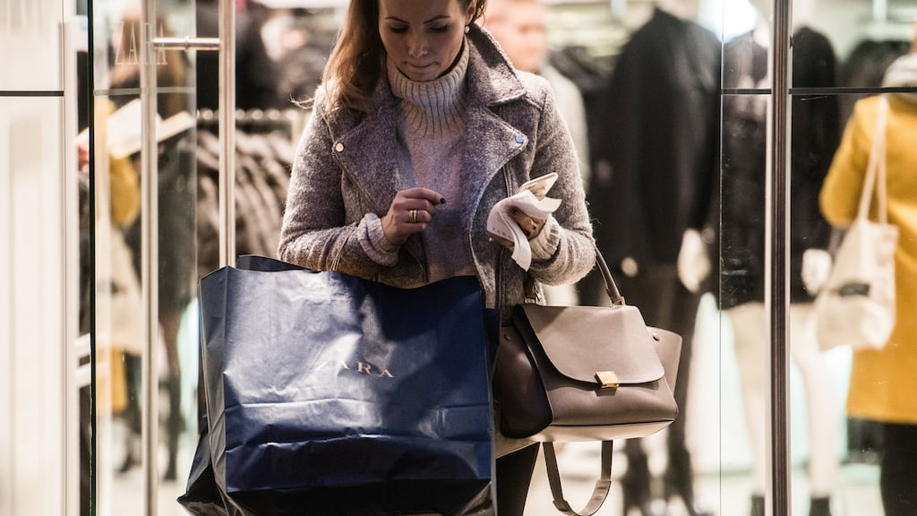 A shopper carries a branded shopping bag as she exits a Zara store. Photograph: Akos Stiller/Bloomberg