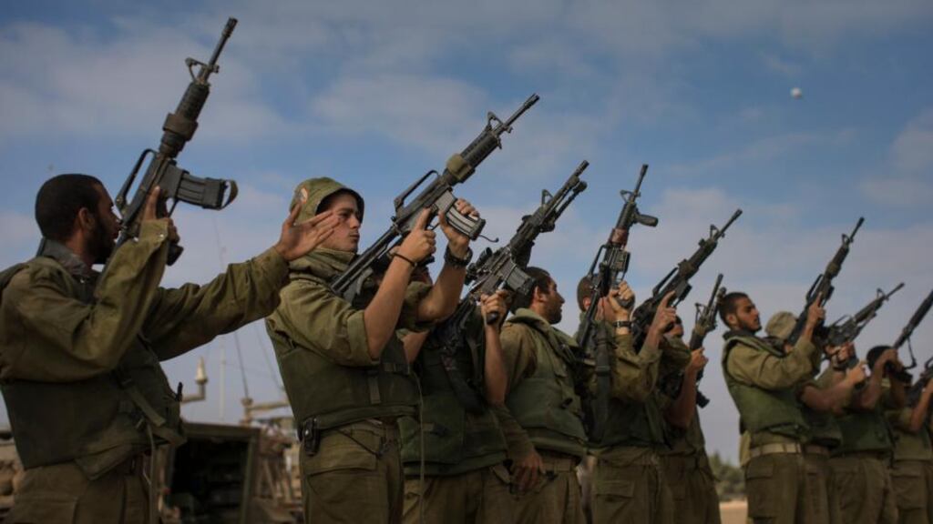 Israeli soldiers inspect their weapons near the Israeli-Gaza border yesterday. Photograph: Uriel Sinai/The New York Times