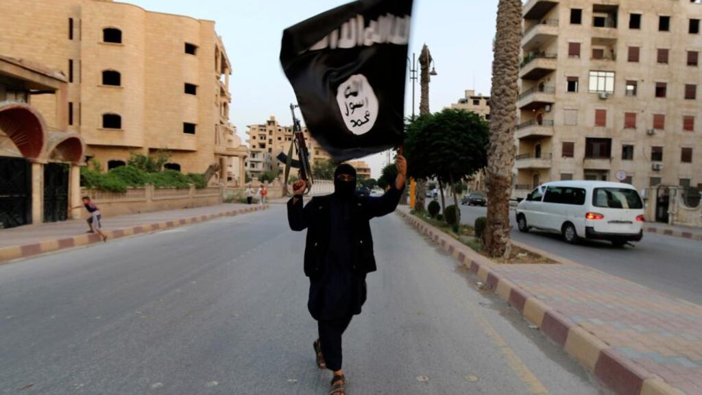 More and more Syrian rebels are defecting to join the ultra-hardline Islamic State insurgency, said UN human rights investigators. A member loyal to the Islamic State in Iraq and the Levant (ISIL or Isis) waves an their flag in Raqqa in June. File.  Photograph: Stringer/Reuters