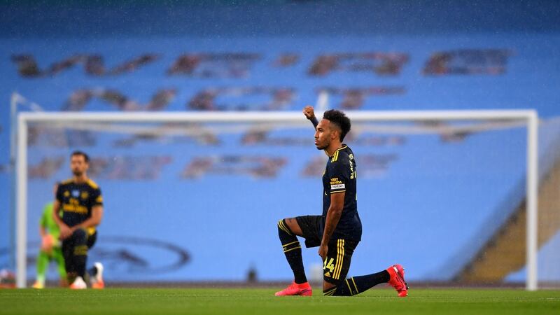 All players took a knee before the game as a statement against racism. Photo: Laurence Griffiths/POOL/AFP via Getty Images