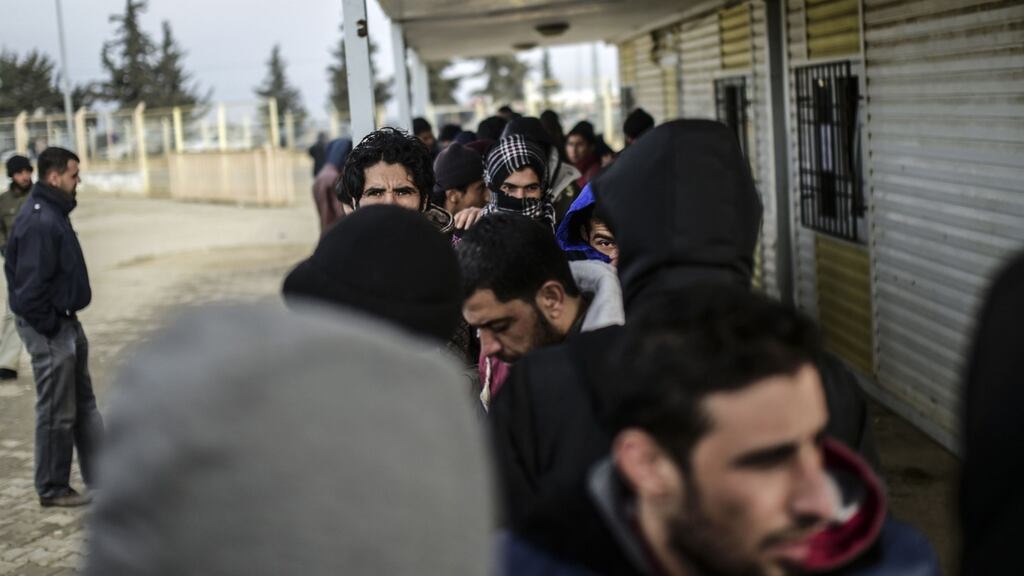 Syrian refugees wait before the Oncupinar crossing gate near the town of Kilis, in south-central Turkey. Photograph: Getty Images