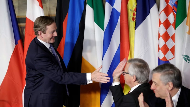 Enda Kenny reaches out to shake hands with European Commission President Jean-Claude Juncker. Photograph: AP/Alessandra Tarantin