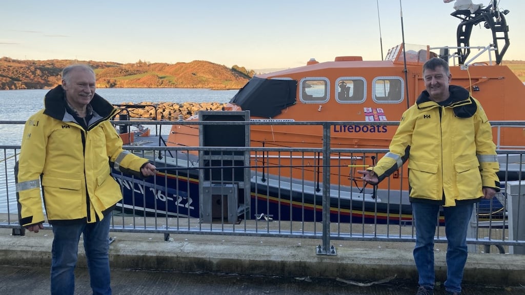Socially distanced by a fishing rod, retiring coxswain Kieran Cotter hands over the lifeboat keys to Baltimore RNLI’s new coxswain Aidan Bushe. Photograph: Micheal Cottrell