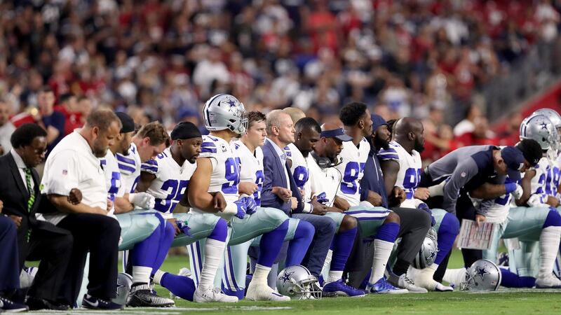 Members of the Dallas Cowboys link arms and kneel during the National Anthem before the start of their meeting with the Arizona Cardinals last year. Photo: Christian Petersen/Getty Images
