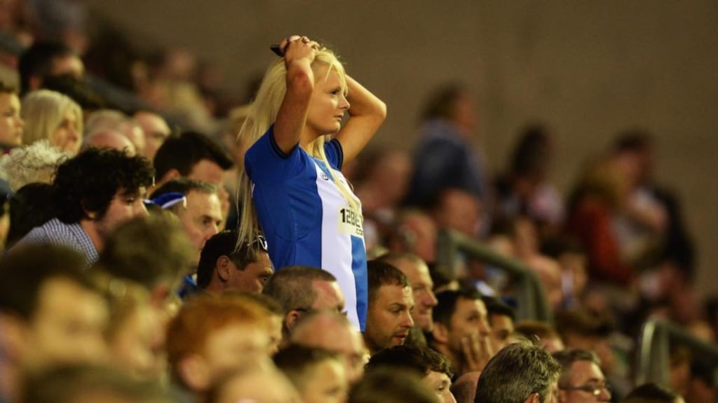 A Wigan Athletic fan despondent during the 3-2 defeat at home to Swansea City. Photograph: Laurence Griffiths/Getty Images