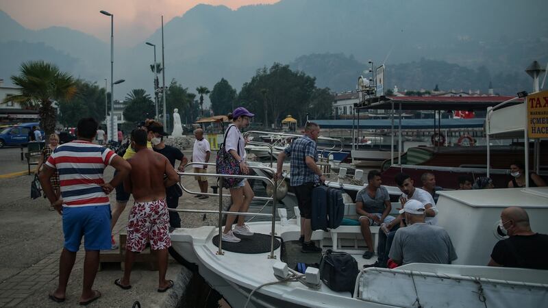 Tourists leave Turunc, in the Marmaris district of Mugla province, by boat on Sunday due to wildfires. Photograph: Erdem Sahin/EPA