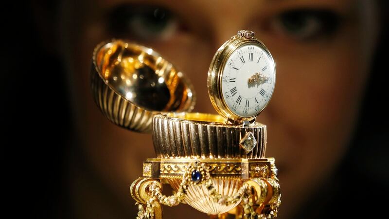 An assistant poses for a photograph with a Faberge egg during a photo-call at antique dealer Wartski, in central London. Photograph: Olivia Harris/Reuters