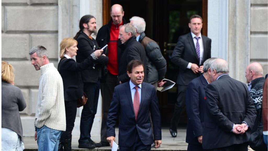 Minister for Justice Alan Shatter walks past Independent TD Luke Ming Flanagan before speaking to the media yesterday.