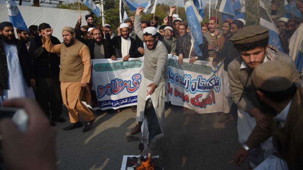 Pakistani students burn images of US president Donald Trump during a protest against aid cuts in Islamabad on Friday. Photograph: Farooq Naeem/AFP/Getty Images