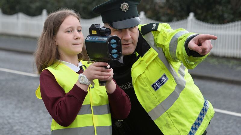 Hannah, a pupil in Annahilt Primary School in Co Down with a police officer outside the school, where police were watching out for speeding drivers. Photograph: Colm Lenaghan/Pacemaker Press