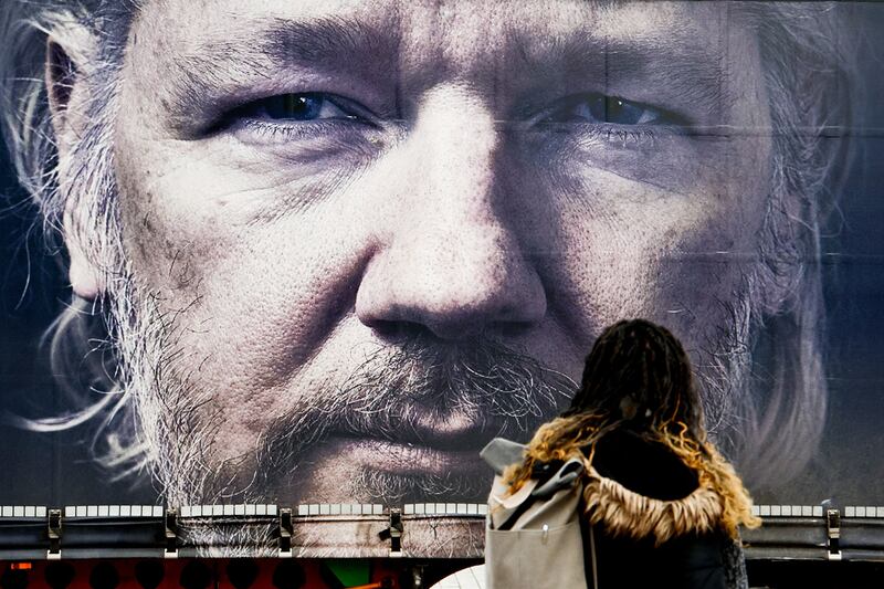 A pedestrian observes truck with giant Assange portrait during a pro-Assange campaigners protest in Berlin, Germany in February 2024.
