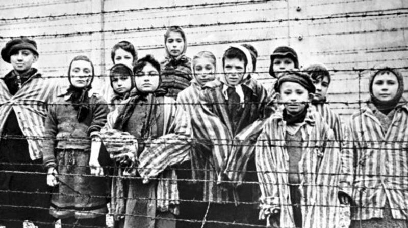 A group of child survivors behind a barbed wire fence at Auschwitz-Birkenau, the Nazi concentration camp, in southern Poland, on the day of its liberation by the Red Army, January 27th, 1945. File photograph: Alexander Vorontsov/Galerie Bilderwelt/Getty