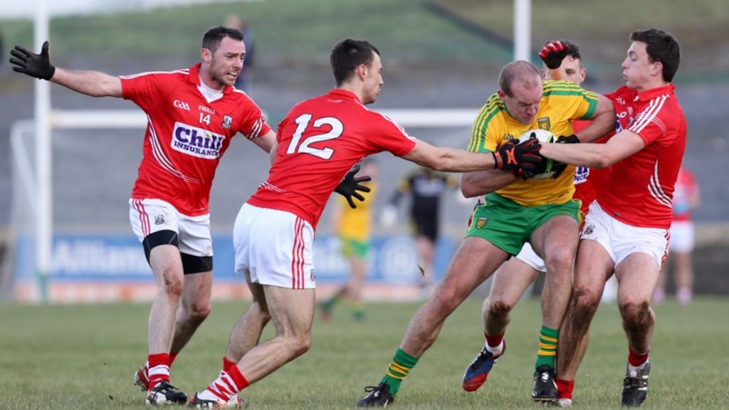 Neil Gallagher is tackled by Cork’s Kevin O’Driscoll and Mark Collins during Donegal’s 0-12 to 1-8 victory. Photograph: Andrew Paton/INPHO/Presseye