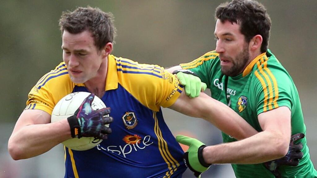 Roscommon’s Kevin Higgins tries to shrug off Leitrim’s Wayne McKeon