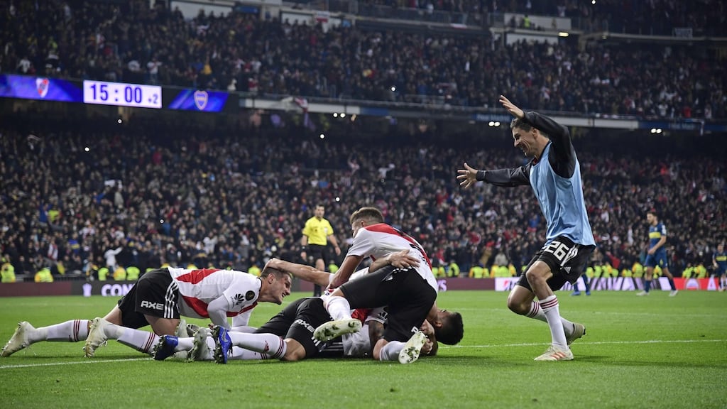 River Plate players celebrate after teammate Gonzalo Martinez (covered) scored their third goal against Boca Juniors to win the Copa Libertadores. Photo: Javier Soriano/Getty Images