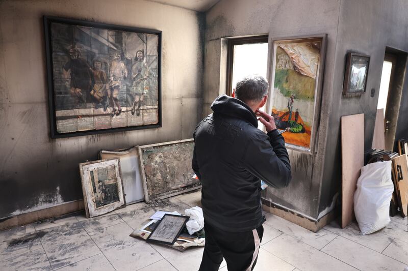 Artist Pat Curran, looks on at some of his work destroyed after an arson attack. Photograph: Dara Mac Dónaill