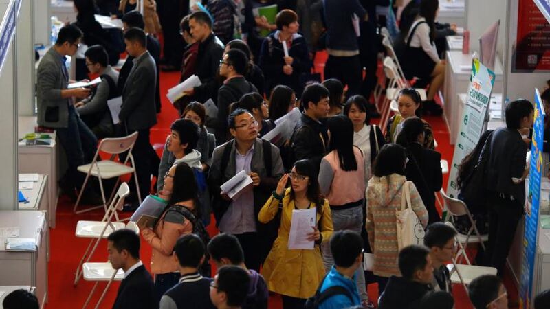 People visit booths during a job fair at Donghua University in Shanghai. China’s economy is slowing to an expected 7.4 per cent growth this year but many governments the world over would envy such a rate of expansion. Photograph: Carlos Barria/Reuters