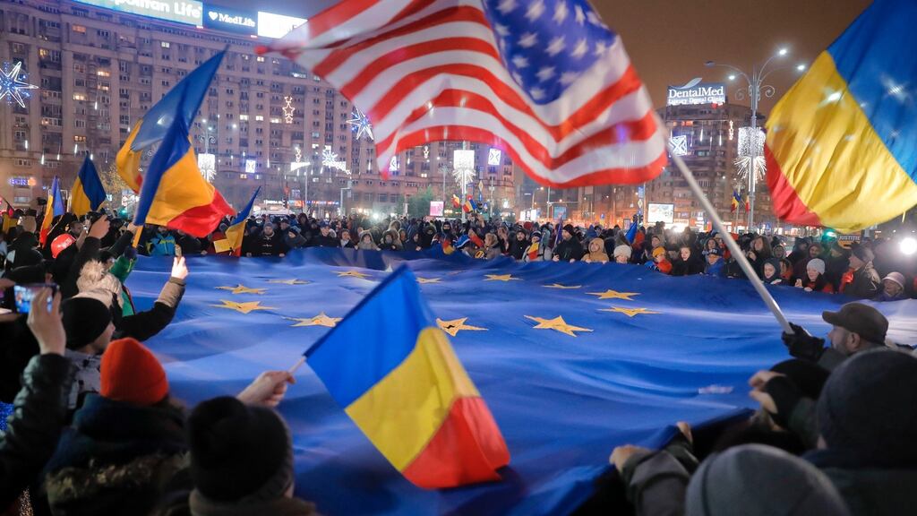 People hold a large EU flag during a protest joined by hundreds in Bucharest on Sunday night. Photograph: Vadim Ghirda/AP