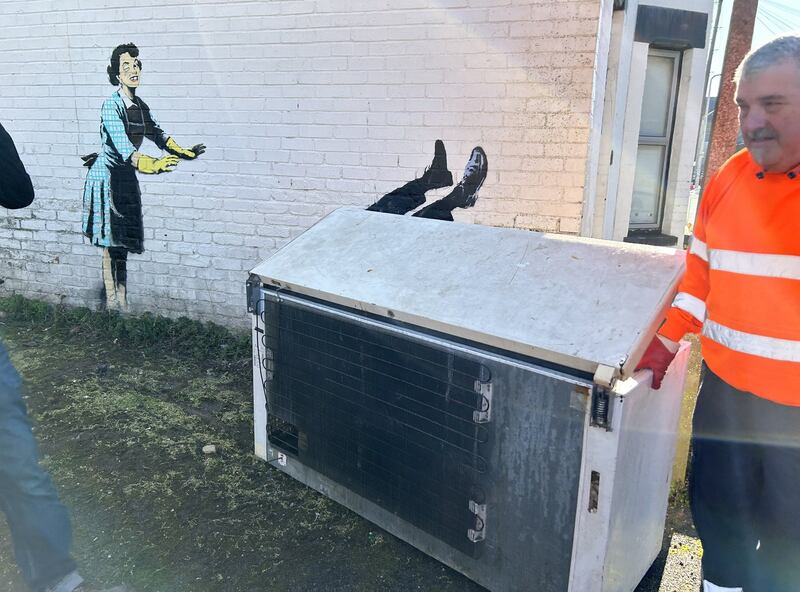 Workers in Margate, Kent removed a chest freezer which formed part of new artwork by street artist Banksy. The piece, titled 'Valentine's Day Mascara', was installed on the side of a building in Margate, Kent. The artwork depicts a 1950's housewife, wearing a classic blue pinny and yellow washing up gloves, with a swollen eye and a missing tooth seemingly shoving her male partner into a chest freezer. Photograph: PA/@danamhiggins