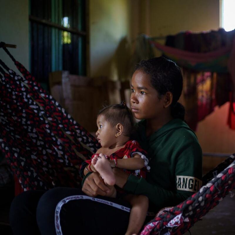 Phoun Phalla, and her baby nephew, in their house in Trapeang Thmor village. Phalla’s parents gave consent for her to participate in the metagenomic study. Photograph: Thomas Cristofoletti/New York Times