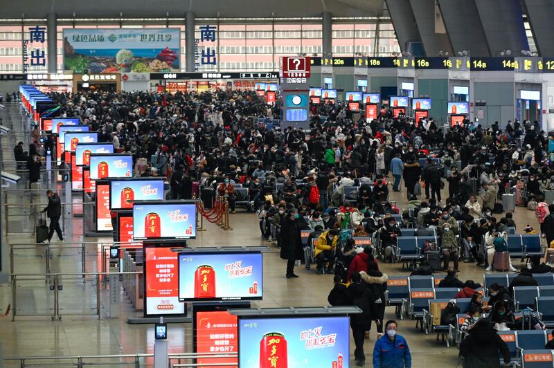 Passengers wait to check in at a railway station in Beijing, as the annual migration begins with people heading back to their hometowns for new year celebrations. Photograph: Wang Zhao/ AFP via Getty