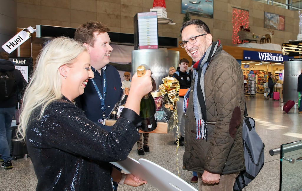 Cork Airport head of development Tara Finn and communications manager Barry Holland, centre, welcome its three millionth passenger of 2024, Dr Muhammad Asim, with a bottle of champagne and a luxury hamper. Photograph: David Creedon.