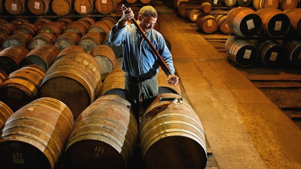 A worker at Bruichladdich distillery in Islay takes a whisky sample from a cask. Photograph: Jeff J Mitchell/Getty Images