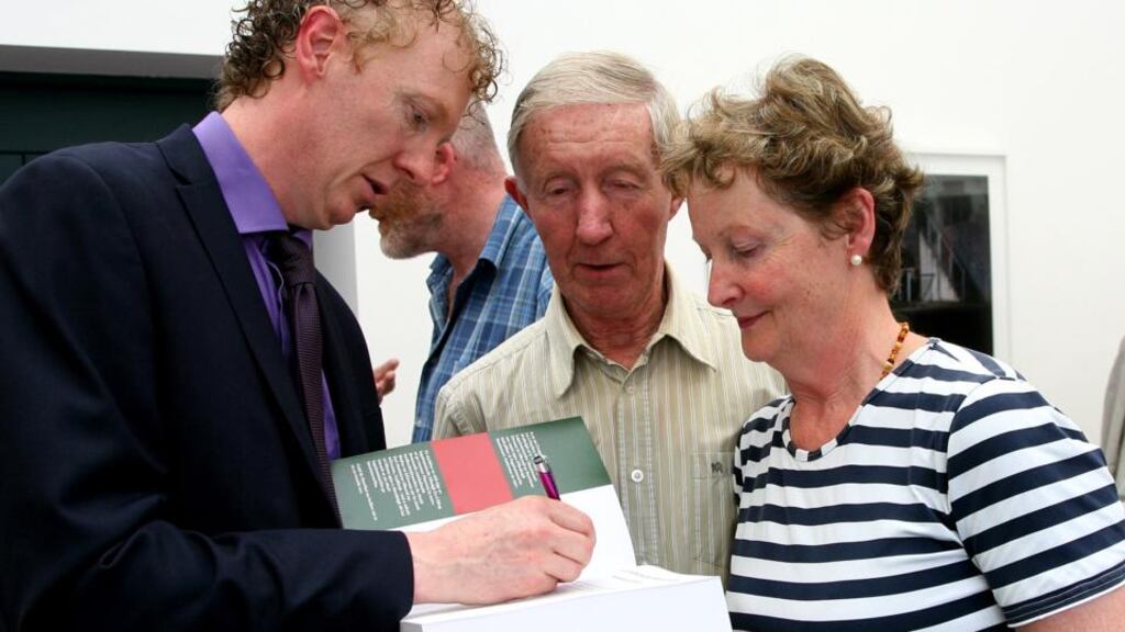 Fiachra Mac Gabhann ag síniú cóipeanna dá leabhar. grianghraf: joy heverin