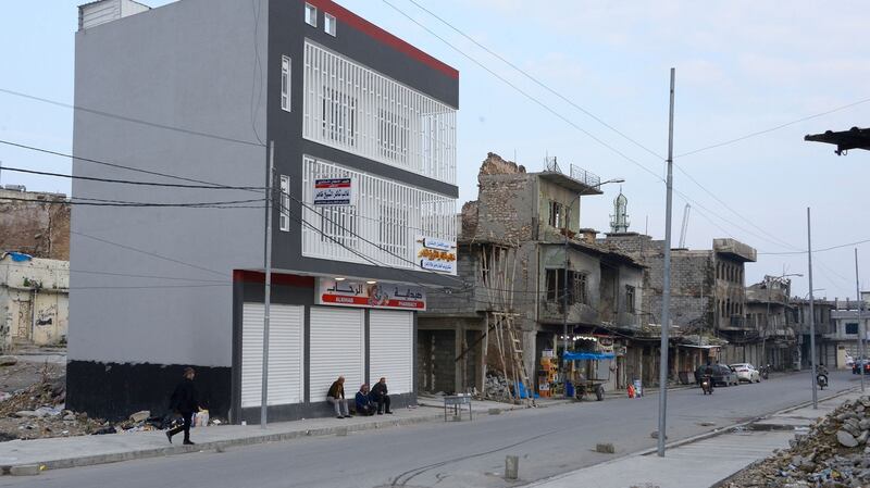 Iraqi men sit by a newly-built building in Mosul on February 21st, 2020. Photograph: Getty Images