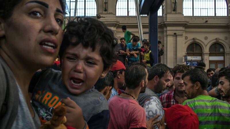 A migrant mother and child attempt to leave the crowd in wait for a train to Germany at Keleti train station in Budapest on Tuesday. Photograph: Mauricio Lima/The New York Times