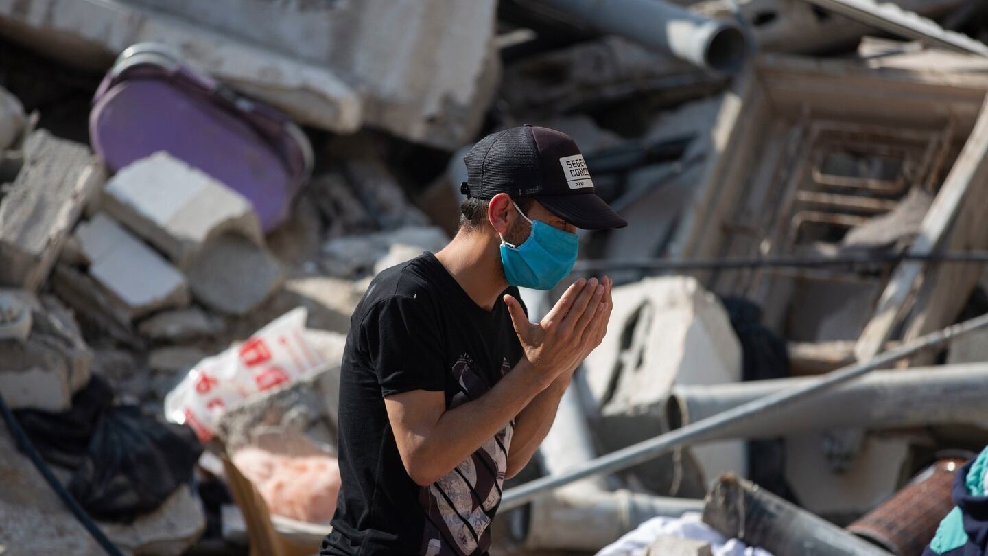 A Palestinian man prays as he stands amid the rubble of buildings destroyed in Gaza City during deadly Israeli air strikes on Sunday. Photograph: Khalil Hamra/AP