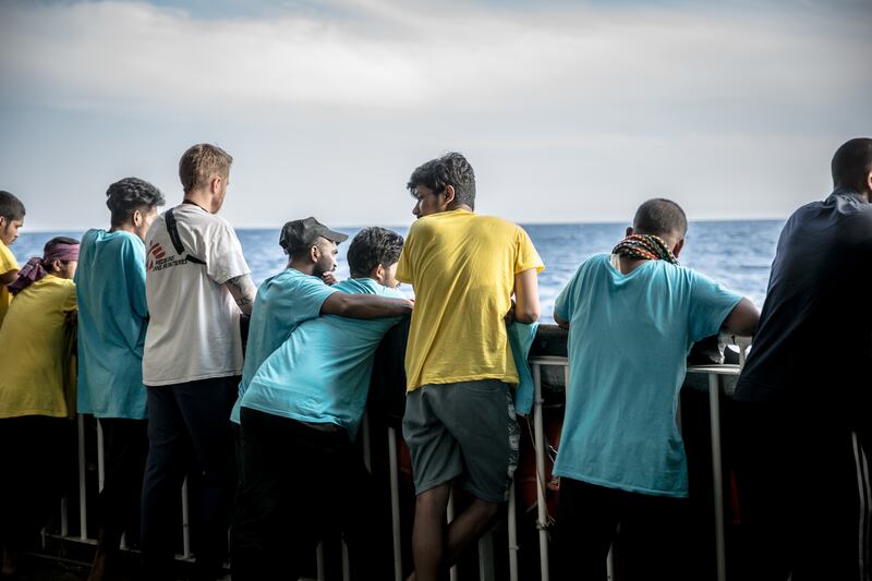 Some of the 73 people taken on board in two rescue operations in the Central Mediterranean look out from the back of the Geo Barents. Photograph: Sally Hayden