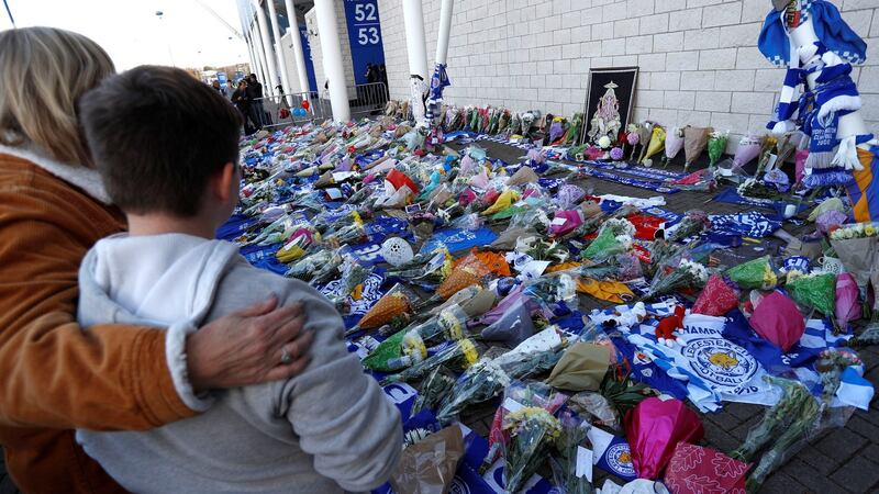 Leicester City football fans pay their respects outside the King Power Stadium, after the helicopter of the club’s owner, Thai businessman Vichai Srivaddhanaprabha, crashed when leaving the ground on Saturday evening. Photograph: Peter Nicholls/Reuters