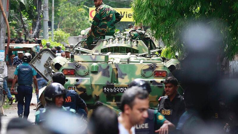 Bangladeshi soldiers and security personnel sit on top of armoured vehicles as they cordon off an area near the restaurant. Photograph: AP