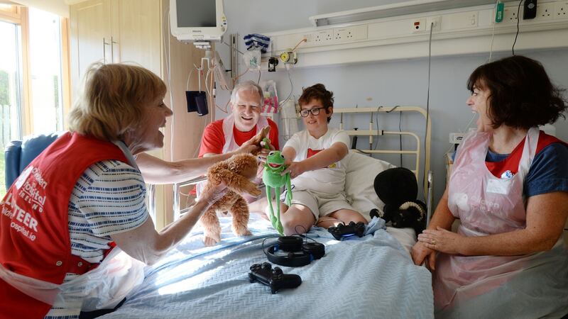 Volunteers Jacinta Nisbet, Ainnle O’Neill and Suzanne Lynch play with Matthew O’Connor (12) from Greystones, Co Wicklow, in Crumlin hospital. Photograph: Alan Betson