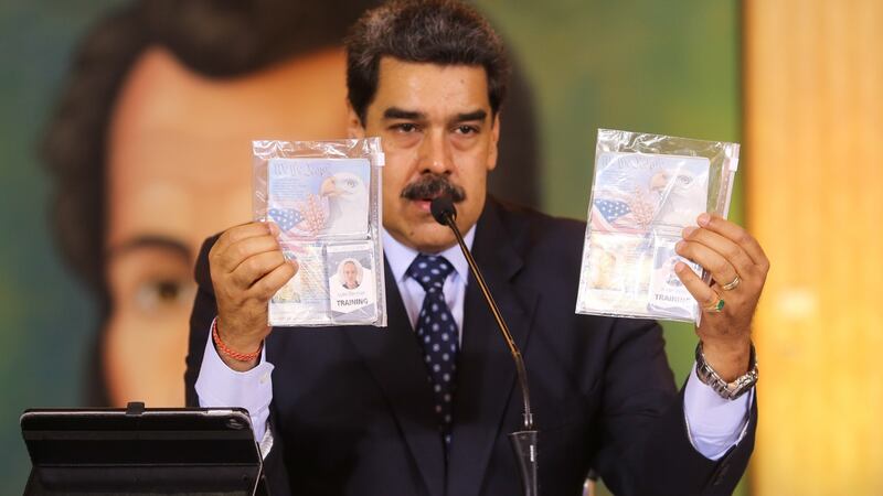 Venezuelan president Nicolas Maduro showing the passports of two US citizens arrested by security forces in his country after an alleged failed plot to capture him. Photograph: Marcelo Garcia/Venezuelan Presidency/AFP via Getty Images.