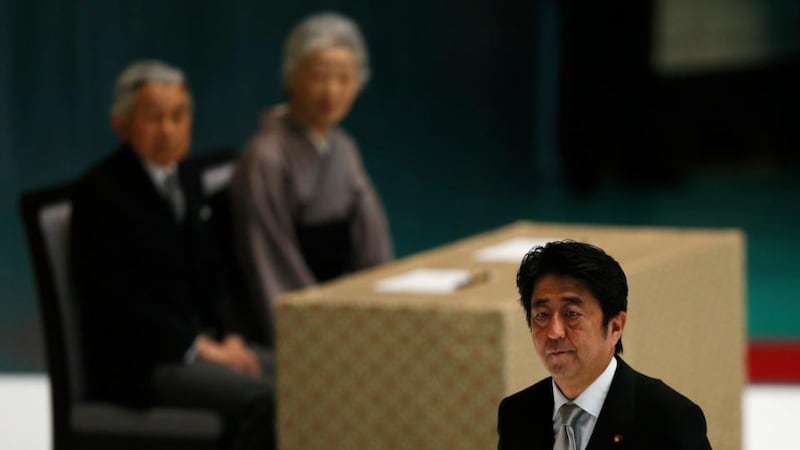 Japan’s prime minister Shinzo Abe (R) walks past Japan’s Emperor Akihito (L) and Empress Michiko during a memorial service ceremony marking the 68th anniversary of Japan’s defeat in World War Two, at Budokan Hall in Tokyo today. Photograph: Toru Hanai/Reuters.