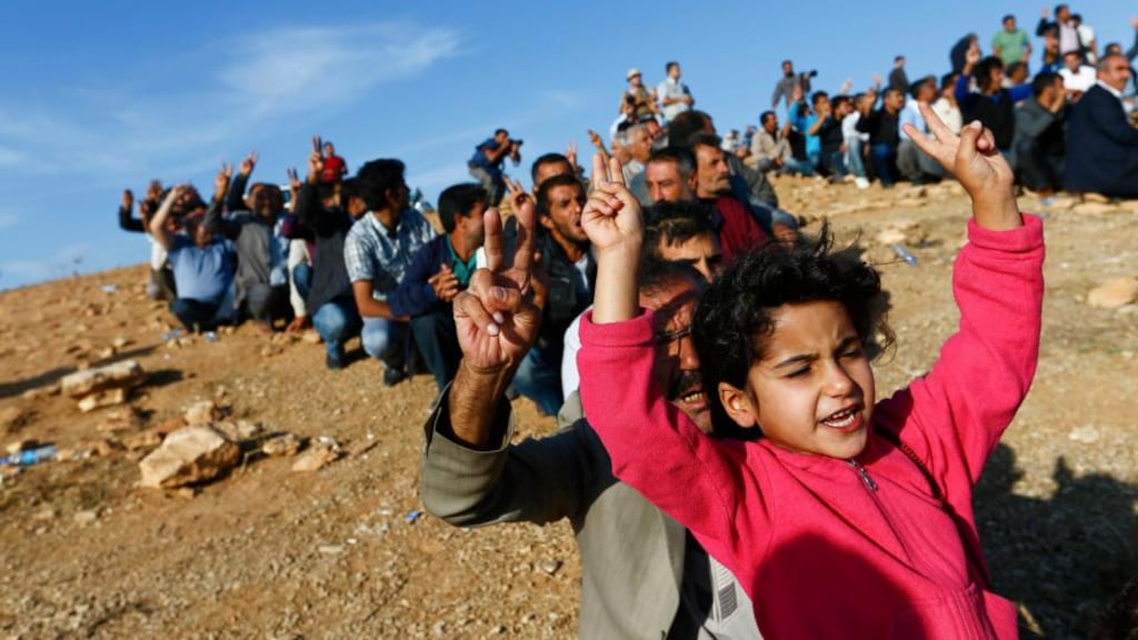 Turkish Kurds shout slogans in support of Kurdish fighters in Kobani as they gather on the hill near a border crossing. Photograph: Kai Pfaffenbach/Reuters