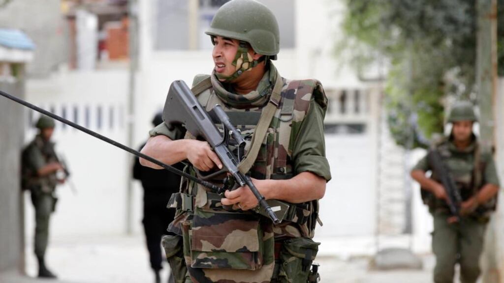 Tunisian soldiers surround the house in Oued Ellil, west of Tunis after heavy exchanges of gunfire. Photograph: Anis Mili/Reuters